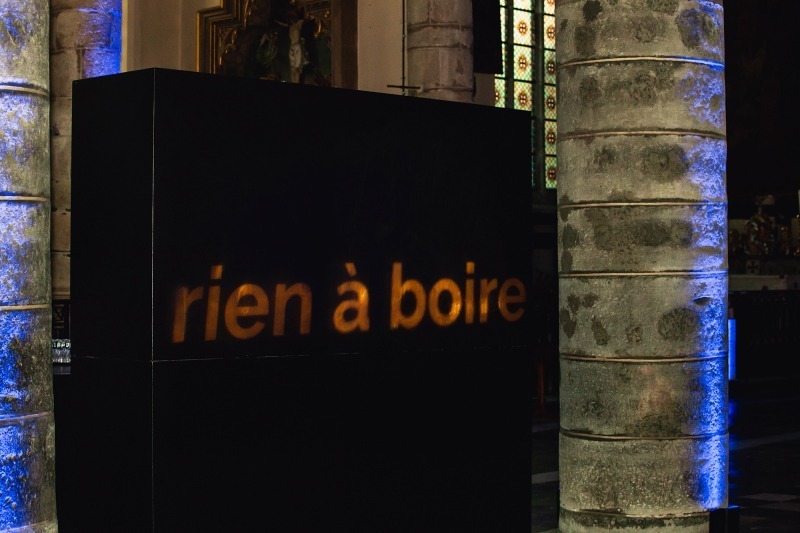 Verlichte letters boven de bar vormen de woorden 'rien à boire'