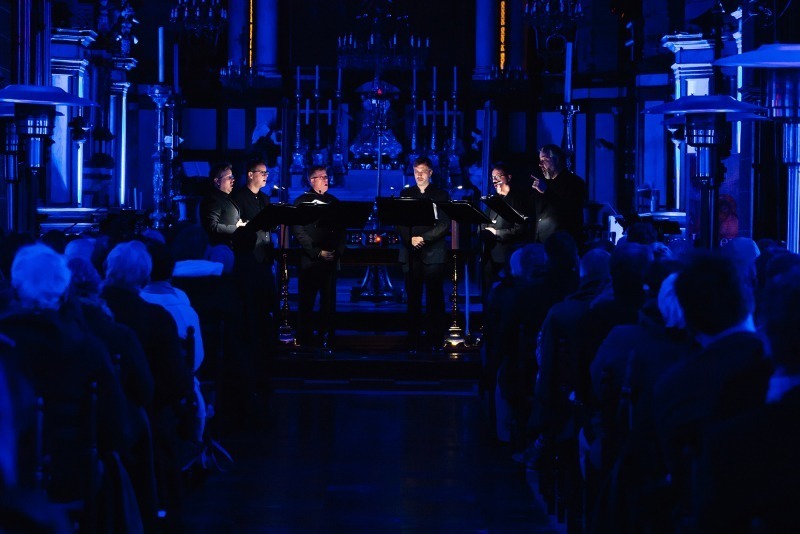 De kerk baadt in blauw licht, enkel de vocalisten zijn verlicht