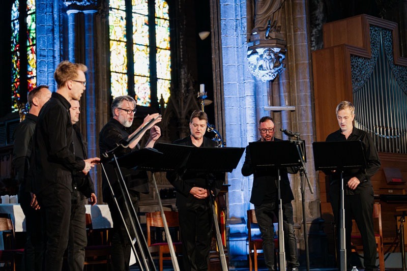 Vooraan in de kerk zingen de 7 leden van Dionysos Now! onder leiding van tenor Tore Tom Denys
