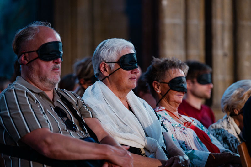 Tijdens het concert dragen de mensen in de kerk een oogmasker om de muziek beter te laten doordringen.