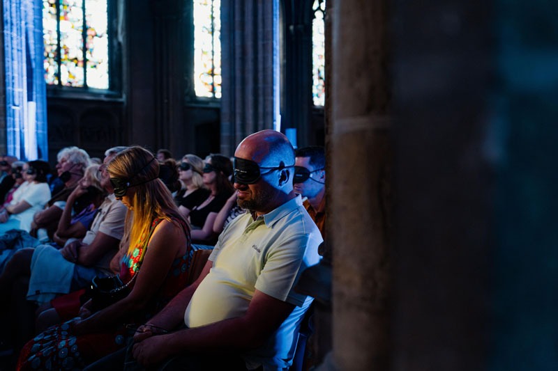 Tijdens het concert dragen de mensen in de kerk een oogmasker om de muziek beter te laten doordringen.