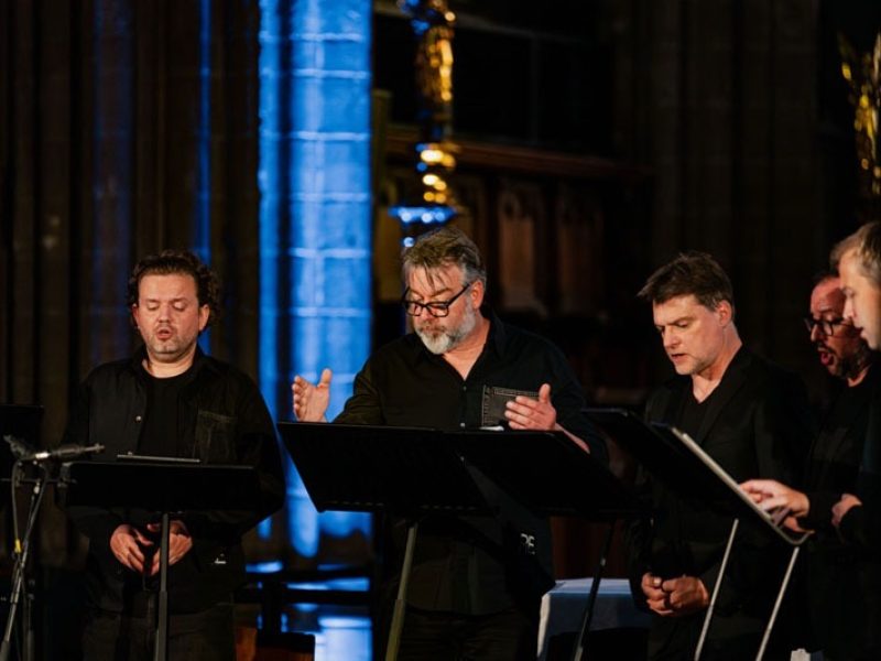 5 des membres de l'ensemble vocal Dionysos Now! Central, le chef d'orchestre donne le rythme.