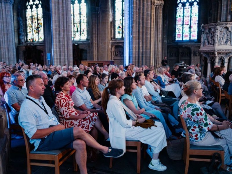 Le public nombreux s'est assis sur les chaises de l'église et a écouté attentivement l'interview.