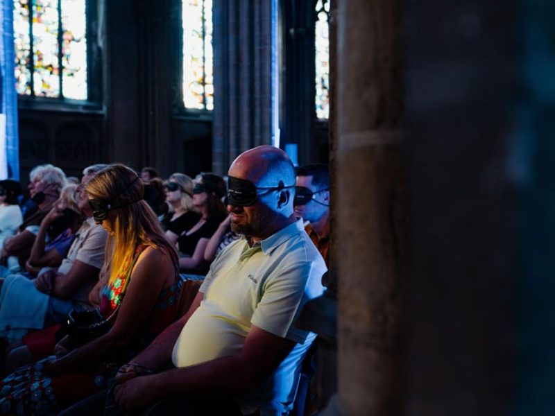 Pendant le concert, les personnes présentes dans l'église portent des masques pour les yeux afin de permettre à la musique de mieux pénétrer.